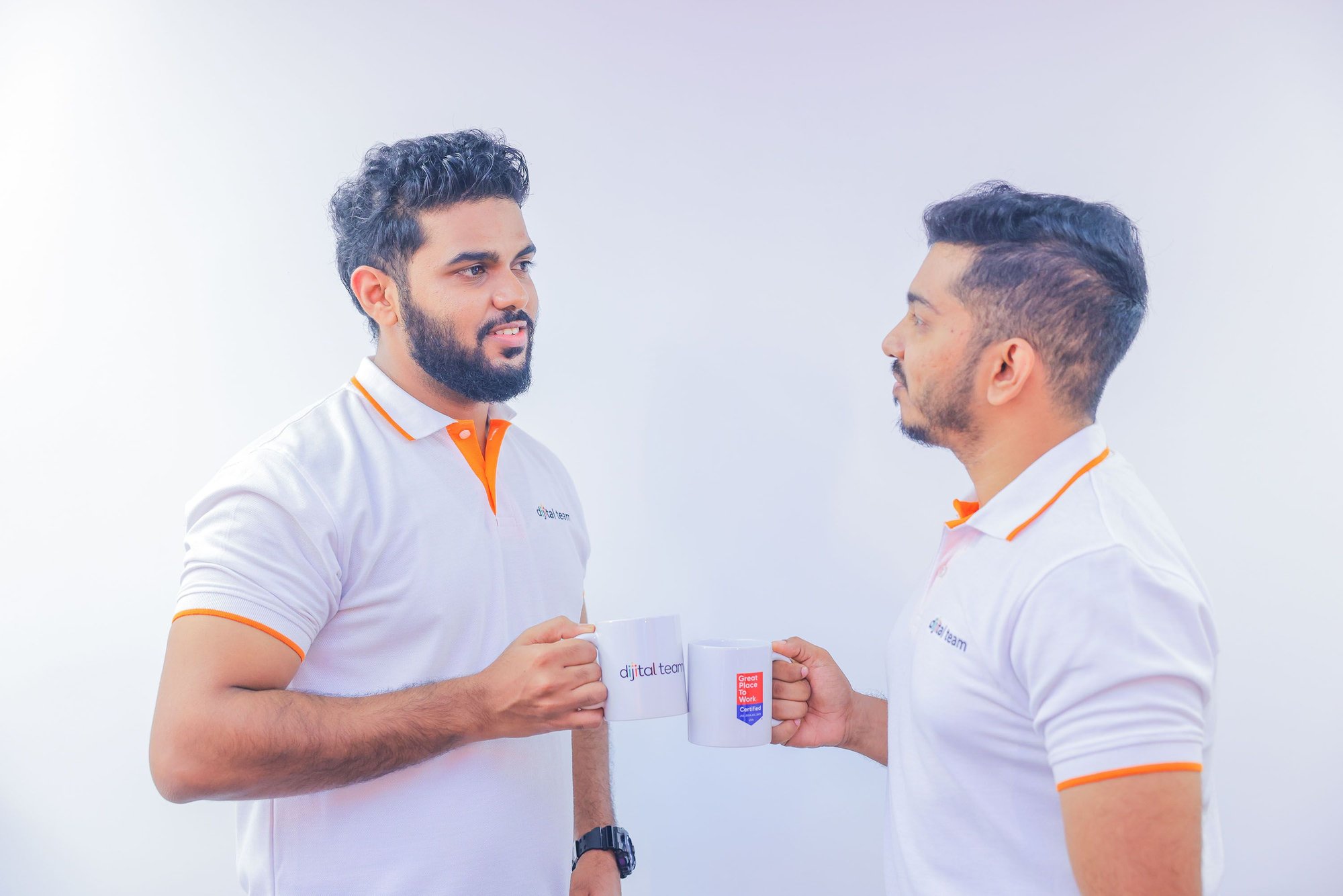 Two Sri Lankan male offshore team holding mug