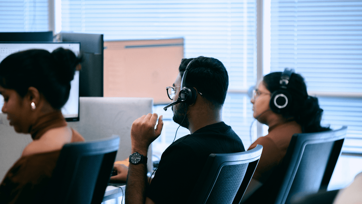 Engineers wearing headsets working at their desks in the office in Sri Lanka